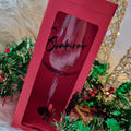 Red gift box with a wine glass inside, featuring the name 'Shakira', on a decorative background.